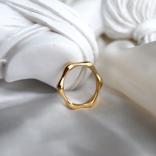 Gold ring on a textured white surface